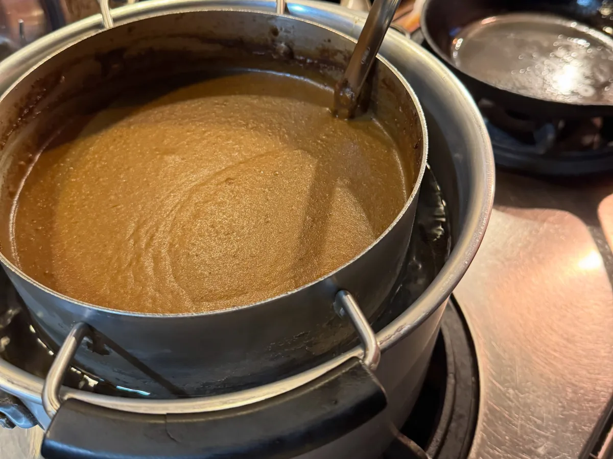 コンロの上の鍋に入った、なめらかなカレーのルー